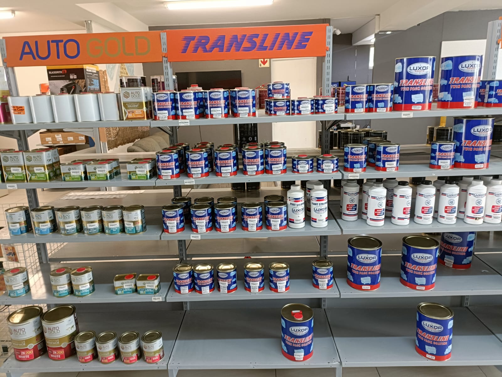 Luxor and Auto Gold paint products displayed on store shelves