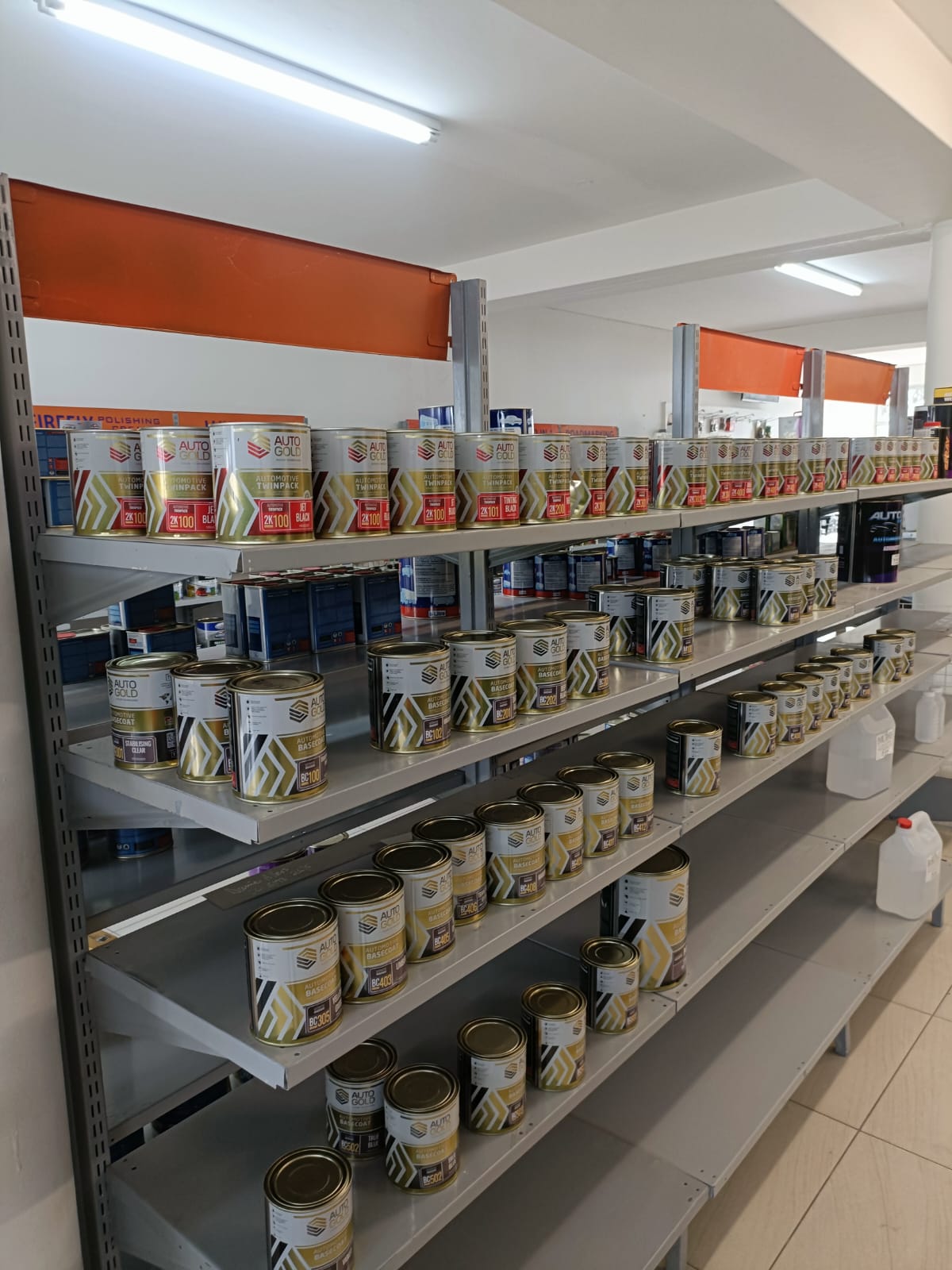 Automotive basecoat and clear products lined on shelves inside Auto Stop Paints and Parts